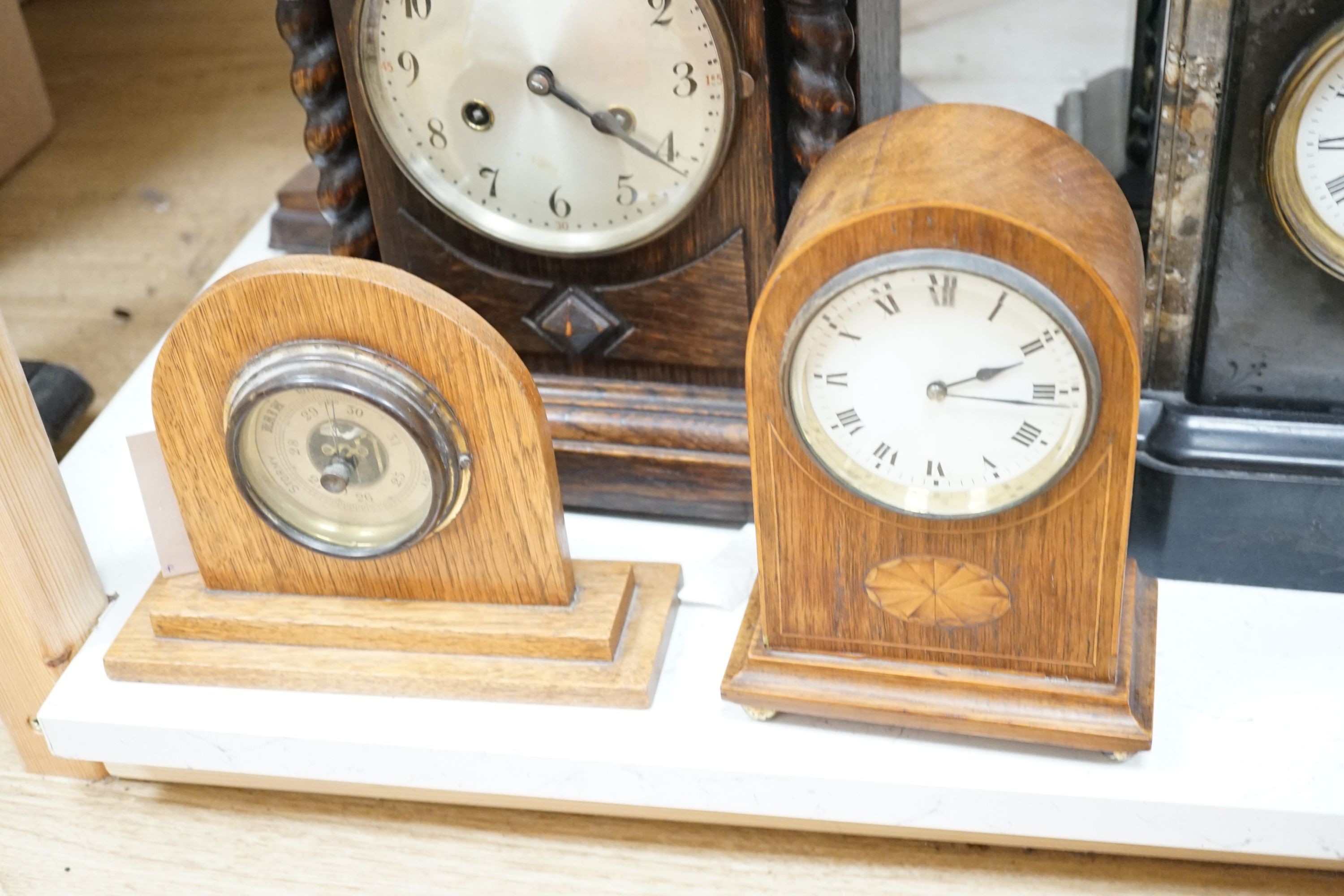 Two 19th century slate mantel clocks, three Edwardian and later wooden mantel clocks and a barometer, tallest 31 cms high.